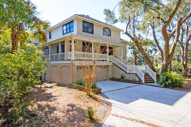 view of front facade featuring a garage, stairs, and concrete driveway