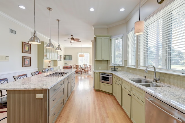 kitchen featuring appliances with stainless steel finishes, visible vents, a sink, and ornamental molding