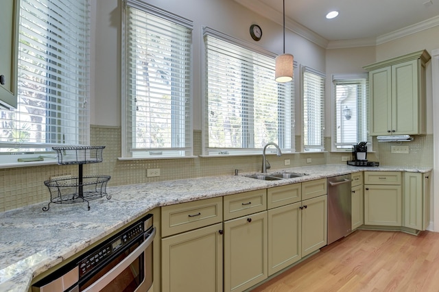 kitchen with stainless steel appliances, cream cabinetry, and a sink