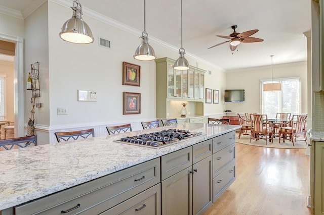 kitchen featuring stainless steel gas cooktop, visible vents, light wood-style floors, and gray cabinetry