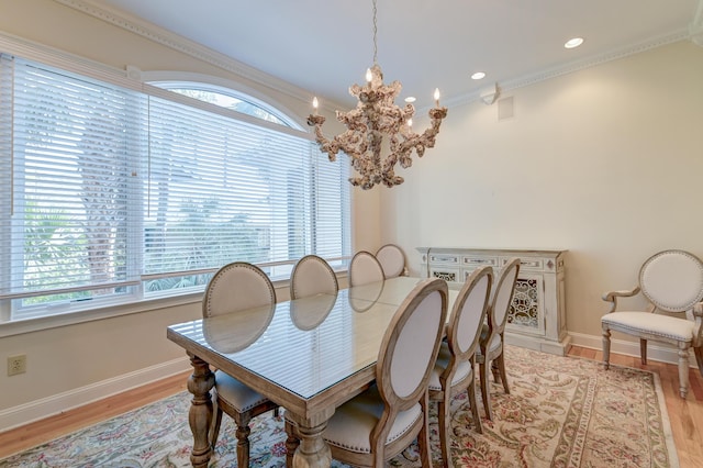 dining room with light wood finished floors, baseboards, an inviting chandelier, crown molding, and recessed lighting