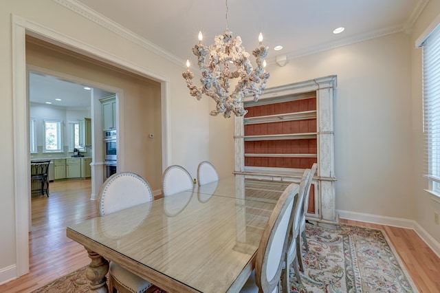 dining space with light wood-style floors, recessed lighting, crown molding, and baseboards