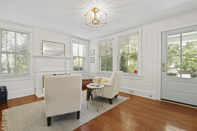 2060 Wappoo Hall Rd, Charleston, SC 29412 - sitting room featuring wood-type flooring, a chandelier, a decorative wall, and baseboards