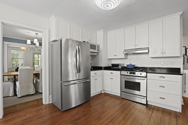 2060 Wappoo Hall Rd, Charleston, SC 29412 - kitchen with stainless steel appliances, under cabinet range hood, dark countertops, dark wood-style floors, and a chandelier