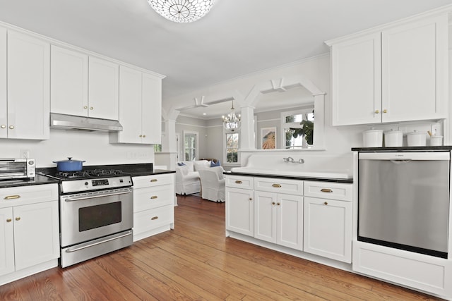 2060 Wappoo Hall Rd, Charleston, SC 29412 - kitchen featuring stainless steel appliances, under cabinet range hood, white cabinets, dark countertops, and light wood-type flooring