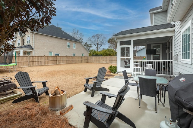 view of patio / terrace featuring a sunroom, a grill, and a trampoline