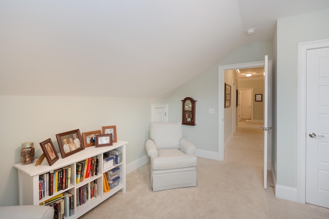 sitting room featuring light carpet and vaulted ceiling