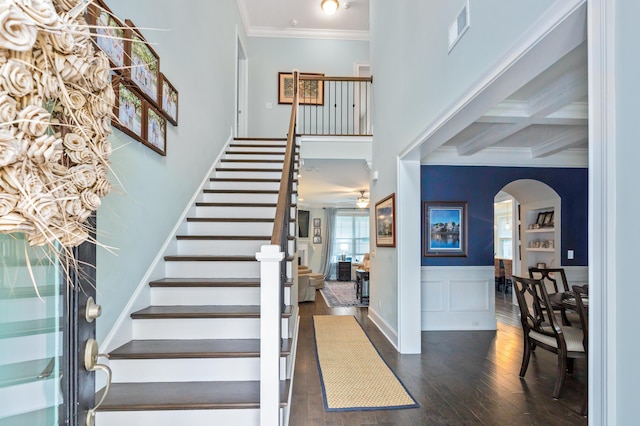 staircase featuring ceiling fan, coffered ceiling, beamed ceiling, crown molding, and hardwood / wood-style floors