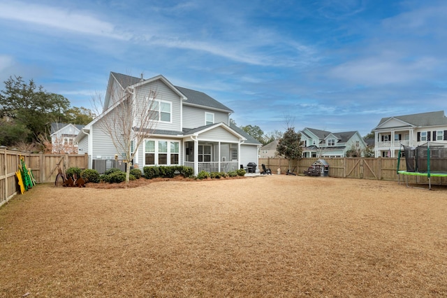 back of property with a sunroom and a trampoline