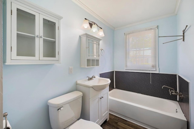 bathroom featuring ornamental molding, a bathing tub, vanity, and toilet