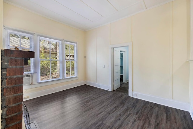 empty room featuring dark hardwood / wood-style floors, ornamental molding, and cooling unit