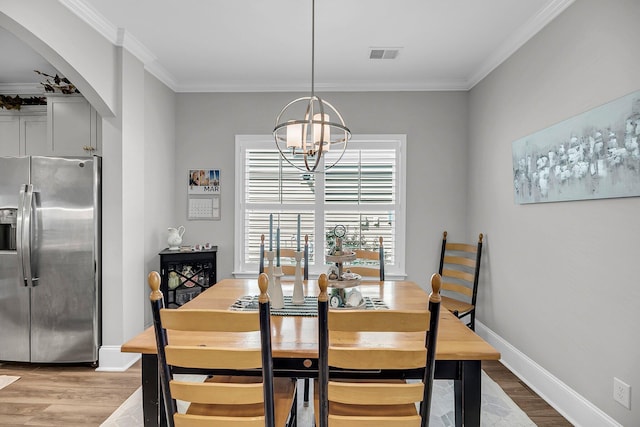 1173 Triple Crown Ct, Mount Pleasant, SC 29429 - dining area featuring an inviting chandelier, light wood-style flooring, arched walkways, and visible vents