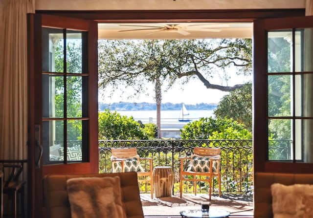 doorway to outside featuring a water view and ceiling fan