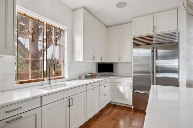 kitchen with white cabinetry, sink, and stainless steel built in fridge