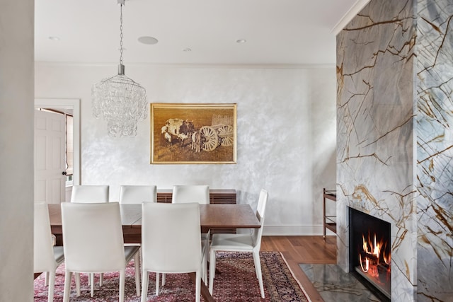 dining room featuring crown molding, wood-type flooring, and a notable chandelier