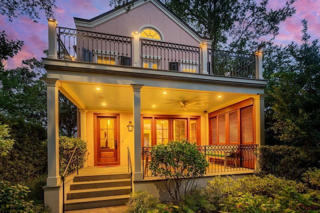 view of front of home with ceiling fan, a balcony, and a porch