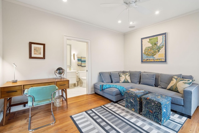 living room with hardwood / wood-style flooring, ornamental molding, and ceiling fan