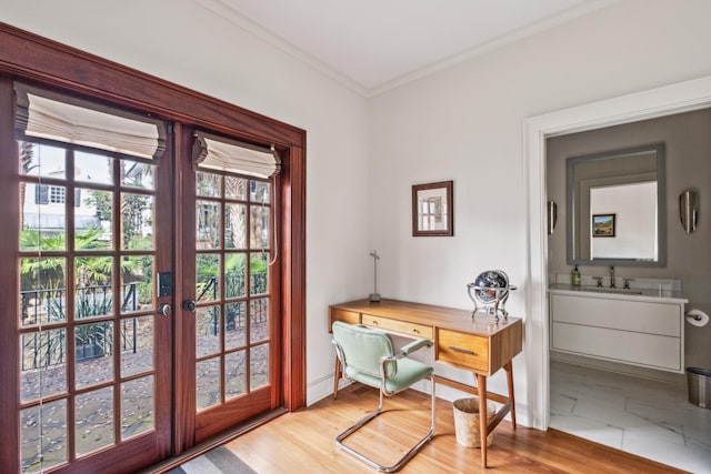 office with crown molding, sink, light hardwood / wood-style flooring, and french doors