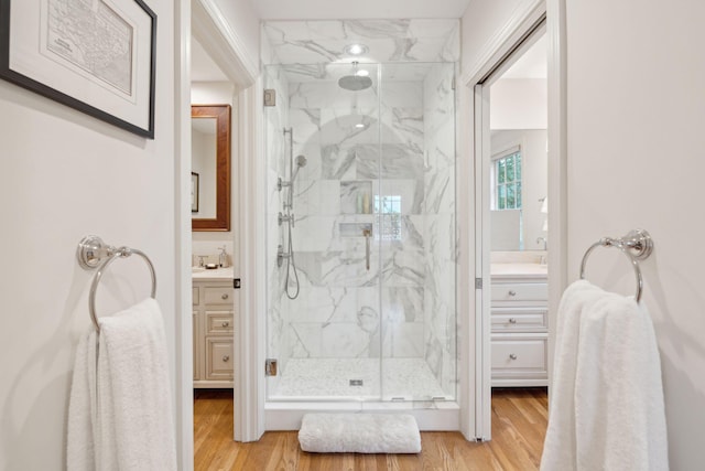 bathroom with vanity, hardwood / wood-style floors, and a shower with shower door