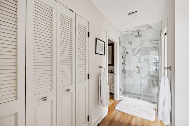 bathroom featuring an enclosed shower and wood-type flooring