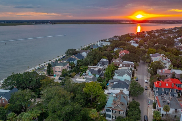 aerial view at dusk featuring a water view