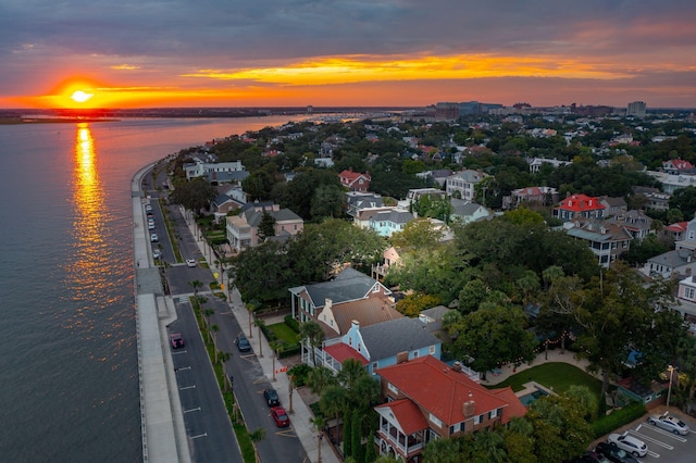 aerial view at dusk featuring a water view