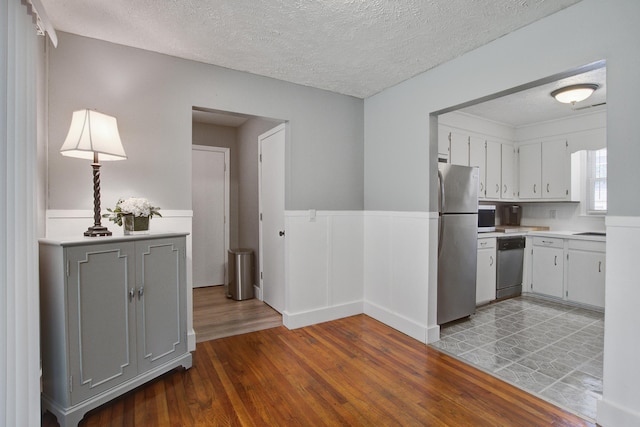 110 Terry Ave, Summerville, SC 29485 - kitchen with stainless steel appliances, wood finished floors, light countertops, a wainscoted wall, and a textured ceiling
