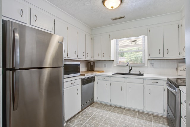110 Terry Ave, Summerville, SC 29485 - kitchen featuring stainless steel appliances, a sink, a textured ceiling, light countertops, and white cabinetry