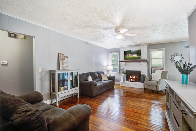 110 Terry Ave, Summerville, SC 29485 - living room featuring a textured ceiling, a ceiling fan, a fireplace, dark wood-style floors, and ornamental molding