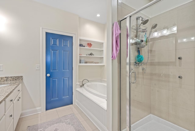 bathroom with plus walk in shower, vanity, and tile patterned flooring