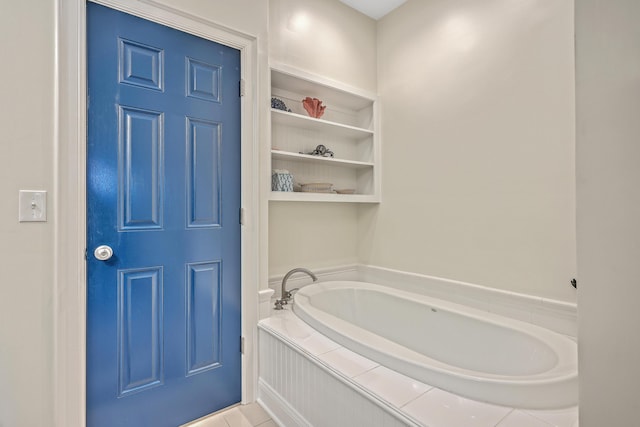 bathroom with tile patterned flooring and a bath