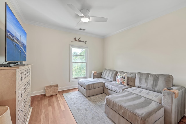 living room featuring ceiling fan, light wood-type flooring, and ornamental molding