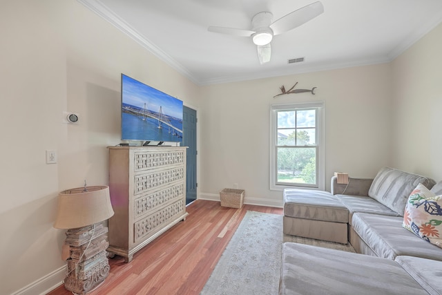 sitting room with ceiling fan, ornamental molding, and wood-type flooring