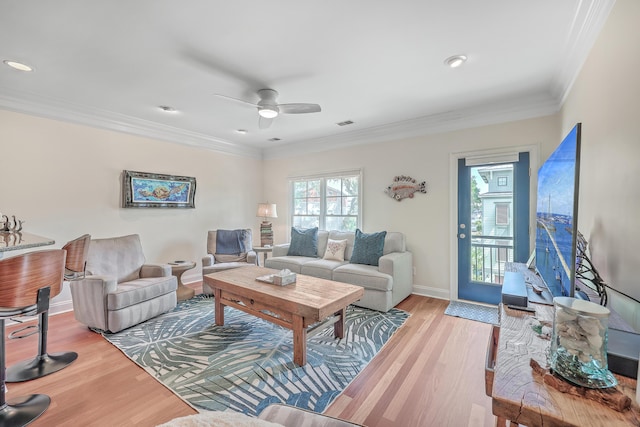 living room with ceiling fan, ornamental molding, and light hardwood / wood-style floors