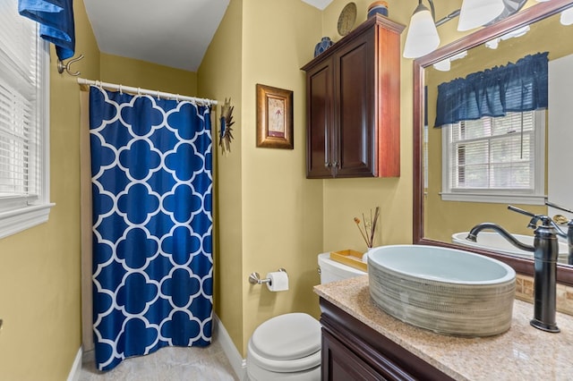 bathroom featuring curtained shower, vanity, and toilet