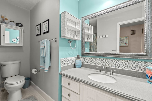 bathroom featuring vanity, decorative backsplash, and toilet