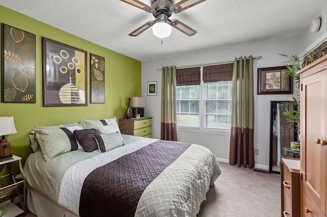 carpeted bedroom featuring ceiling fan and a textured ceiling