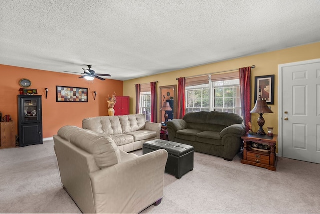 carpeted living room featuring ceiling fan and a textured ceiling