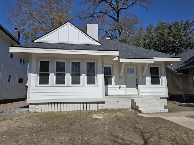 view of front of property with roof with shingles and a chimney