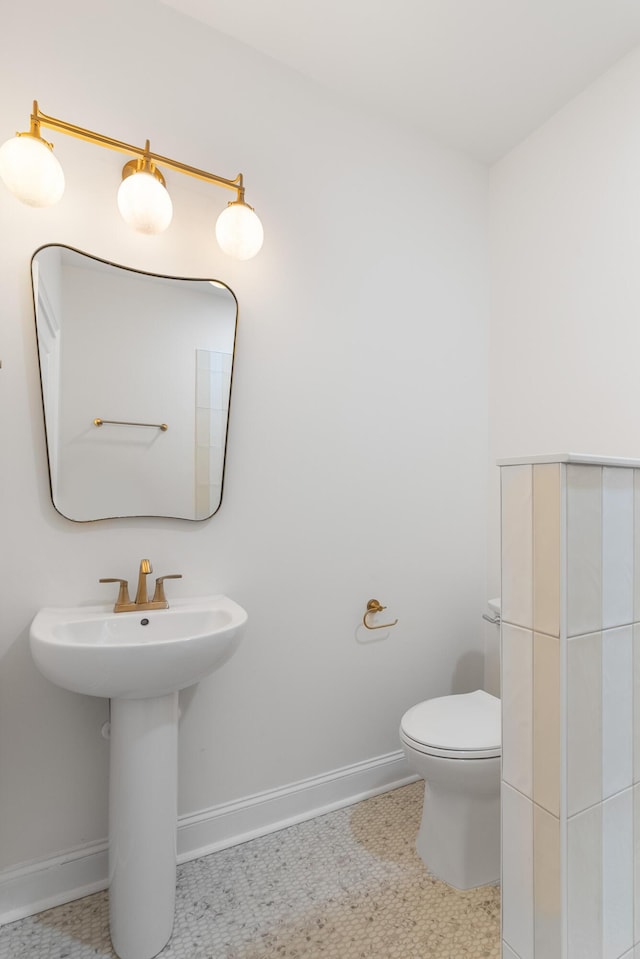 bathroom with toilet and baseboards