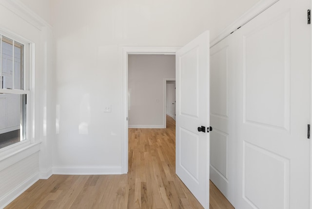 unfurnished room featuring baseboards and light wood-style flooring