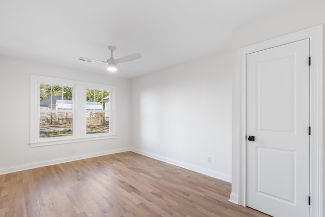 unfurnished room featuring visible vents, a ceiling fan, light wood-style floors, and baseboards