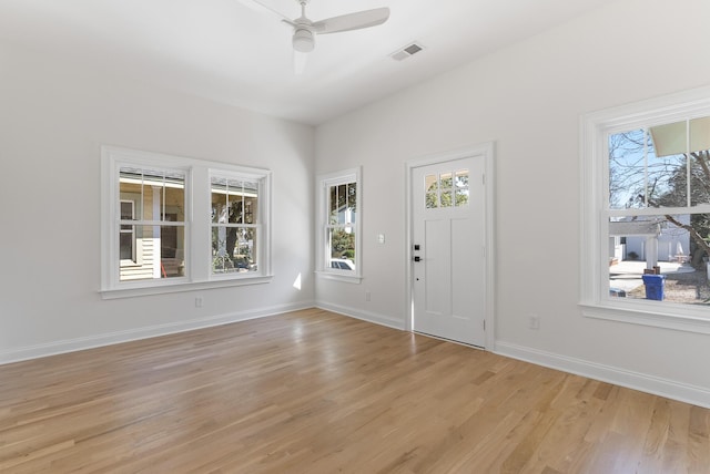 foyer entrance with visible vents, baseboards, light wood-style floors, and a ceiling fan