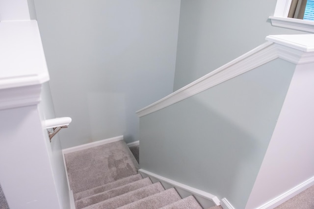 staircase featuring carpet flooring and baseboards