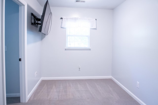 carpeted spare room featuring baseboards