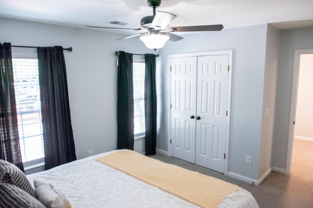 bedroom featuring a closet, baseboards, carpet, and ceiling fan