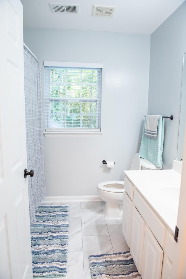 bathroom featuring vanity, toilet, marble look tile flooring, baseboards, and curtained shower