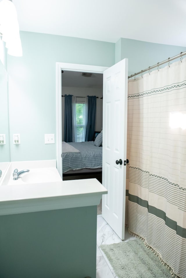 ensuite bathroom featuring marble look tiles, vanity, and a shower with shower curtain