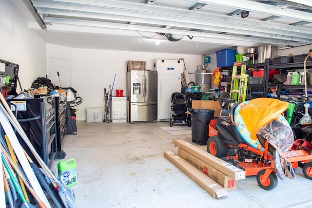 garage with stainless steel refrigerator with ice dispenser, water heater, and refrigerator