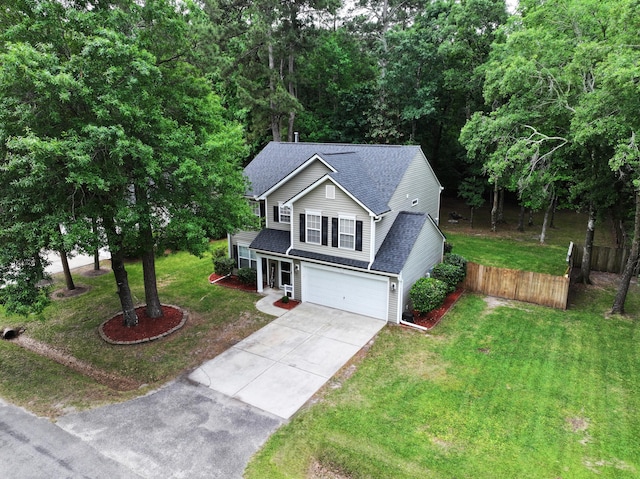 traditional-style house featuring concrete driveway, a garage, and a shingled roof